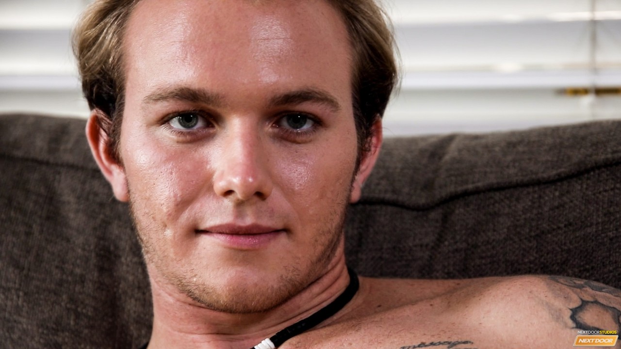 Cute tattooed jock Rex Tanner strips on the sofa and chokes the monkey  