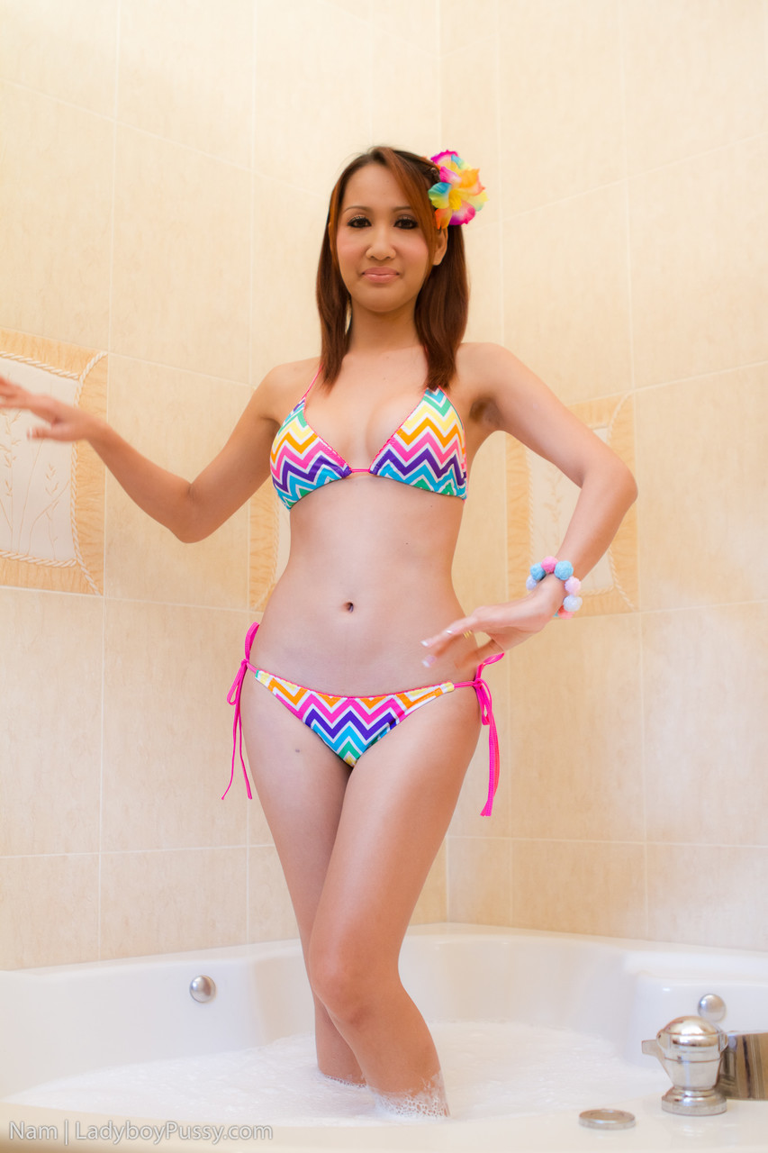 Pretty Ladyboy Nam strips her bikini off in the bathtub and shows nice tits  